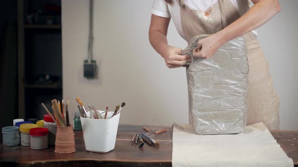 Woman Is Unpackaging Clay for Modeling in Working Studio,