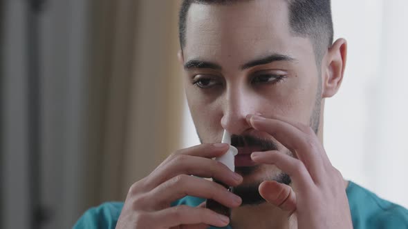 Portrait of Sick Caucasian Man Doctor in Nurse Medical Uniform Treating Runny Nose Using Nasal Spray