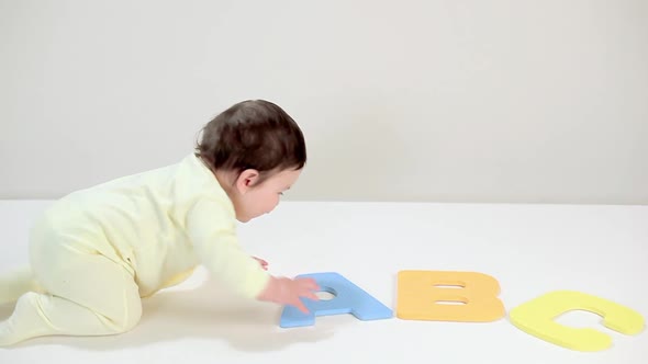 Baby boy playing with toy alphabet blocks