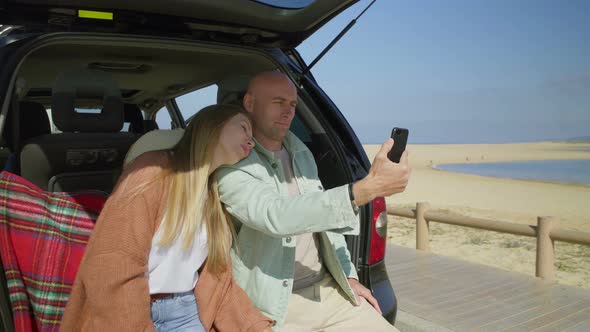 Couple Photographing with Smartphone in Car