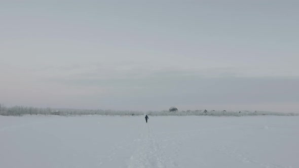 A Man Running Along a Path in a Snowy Field