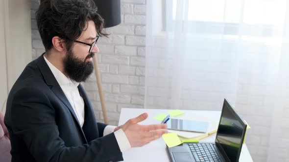 Bearded Man Comfortable at His Desk Having a Video Call Conference