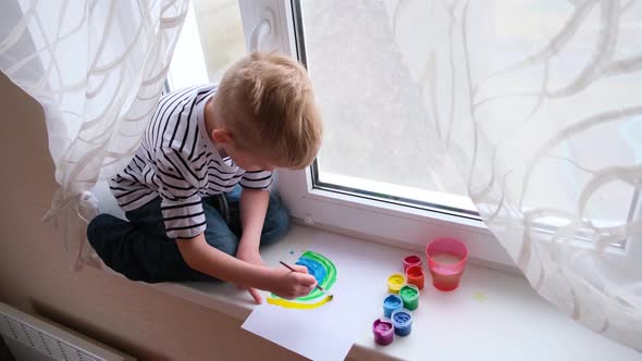 Little Blonde Boy Painting Rainbow During Covid19 Quarantine at Home