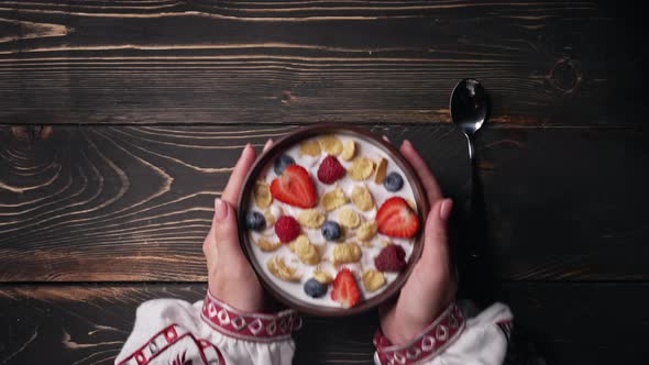 Female Hands Puts and Takes Away Breakfast  Cereal with Milk and Berries