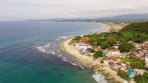 Sandy Coast, Buildings and Blue Sea with Waves. San Juan, La Union, Philippines