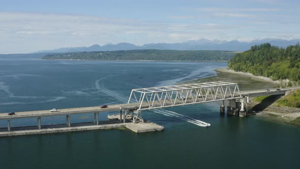 Stunning Aerial Drone Shot Of Speed Boat Crossing Under Hood Canal Bridge In Washington State