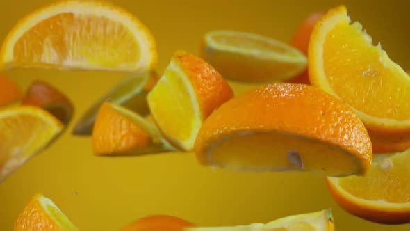 Juicy Sweet Slices of Orange are Flying Up on the Yellow Background