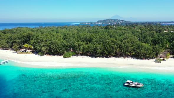 Beautiful birds eye travel shot of a white sandy paradise beach and aqua blue ocean background in co