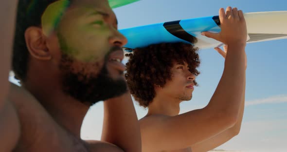 Young friends carrying surfboard on head 4k