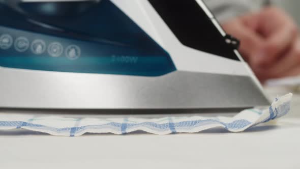 Woman Ironing Bath Towels on Iron Board Closeup