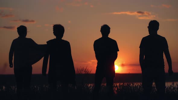 Silhouettes of Young People Have Fun at Sunset