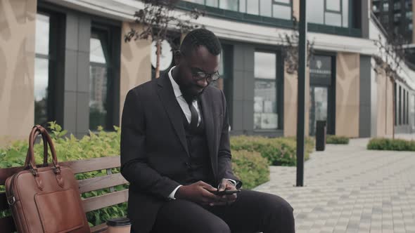 African-American Businessman Sitting on Bench Outside