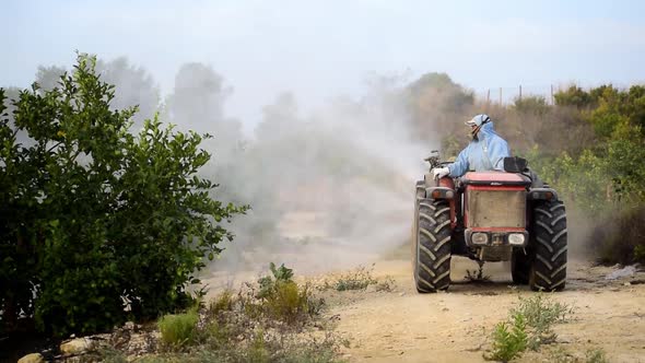 Farm worker spray pesticide driving tractor