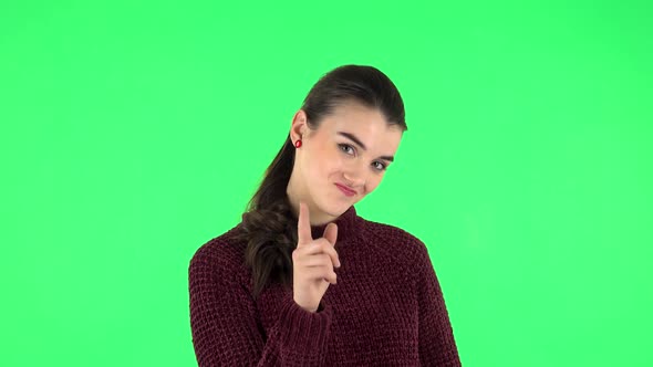 Girl Listens Carefully, Threatens with a Finger Seductively. Green Screen