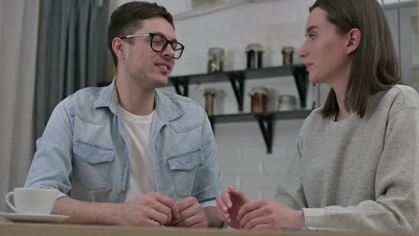 Cheerful Young Couple Talking in Living Room 