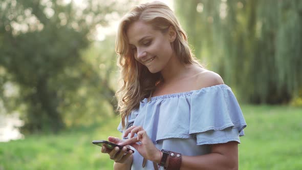 Female Typing Message on Smartphone and Smile