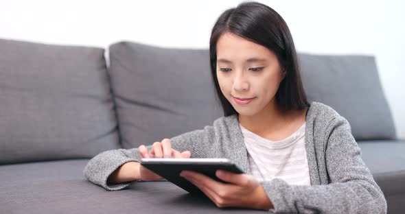 Woman using tablet computer at home