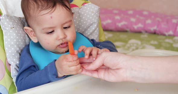 Mom Feeds the Boy with a Spoon and Hand Family Food and Parenthood Concept