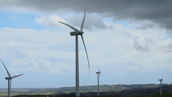 Turbine Blades Spinning on Large Wind Farm, Stormy Sky, Renewable Energy Source