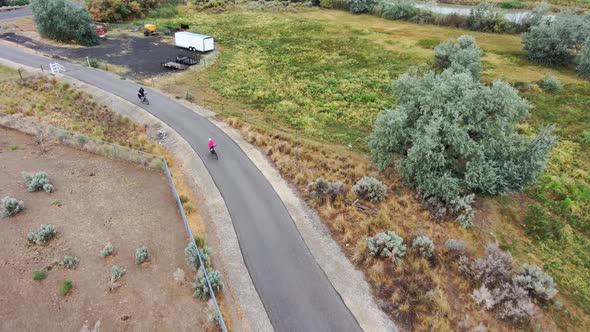 Mature couple cycling along a rural nature trail - aerial tracking view