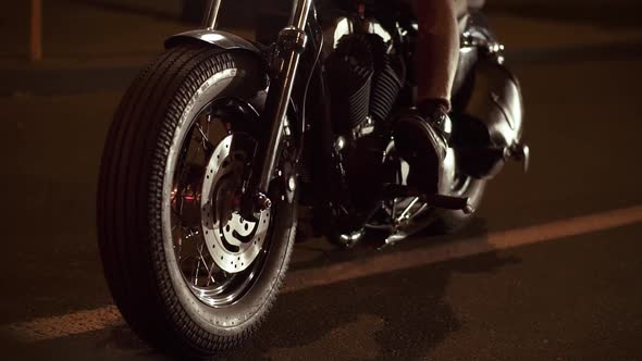 Close Up of Steel Chrome Wheels a Motorcyclist Drives a Bike in the Night City Waiting Traffic Light