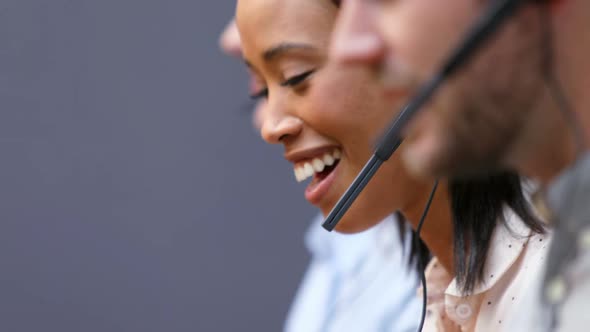 Smiling customer service executives talking on headset at desk 4k