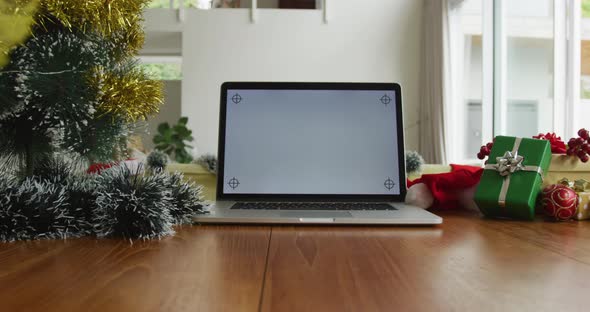 Close up of laptop with copy space on screen, sitting on table in living room at christmas