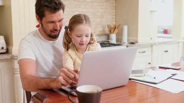 Smiling father sitting on chair assisting his daughter with laptop 4K 4k