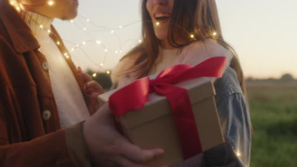 Lovely Valentine's Couple with Gift Box in the Night with Led Strip Lights