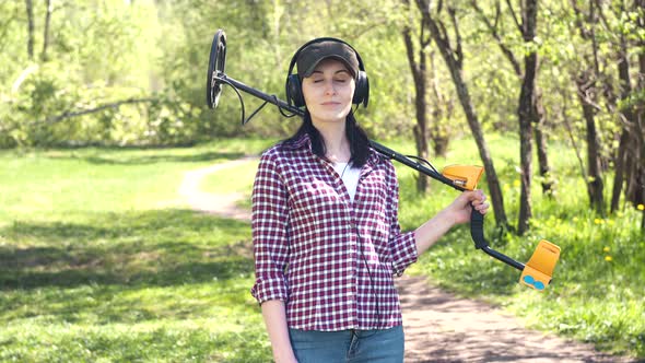 Portrait of a Girl Treasure Hunter with a Metal Detector Looking at Camera