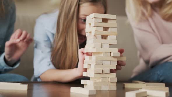 Happy Family Playing Funny Board Game Enjoying Leisure Time Sitting on Cozy Couch at Home Smiling