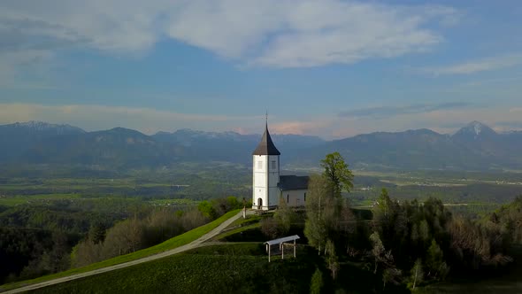 drone footage sunset at Church of St. Primus and Felician, Jamnik, Slovenia