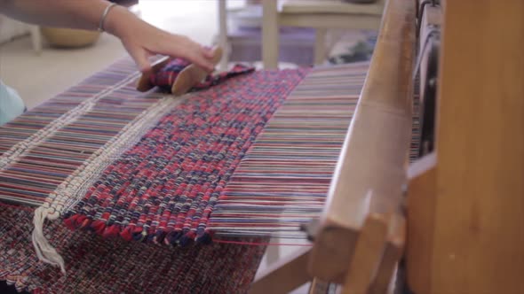 Artisan weaves a rug