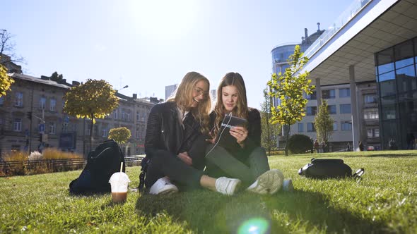 Caucasian Girlfriends Using the Tablet Computer Laughing at Fun Pictures