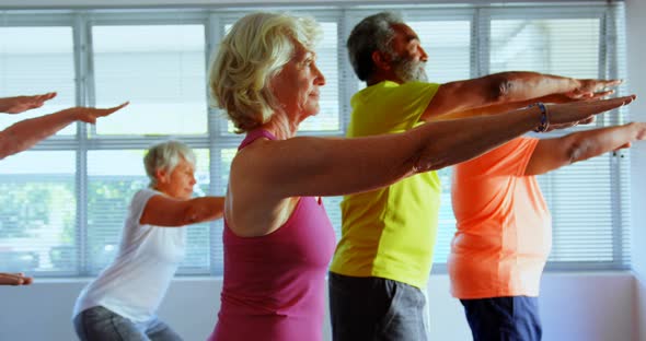 Side view of active mixed-race senior people exercising in the fitness studio 4k