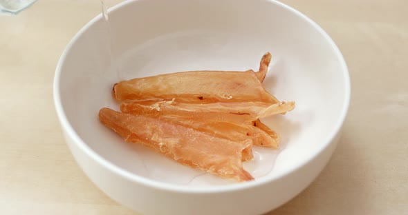 Prepare dry fish maw to cook, add water into bowl