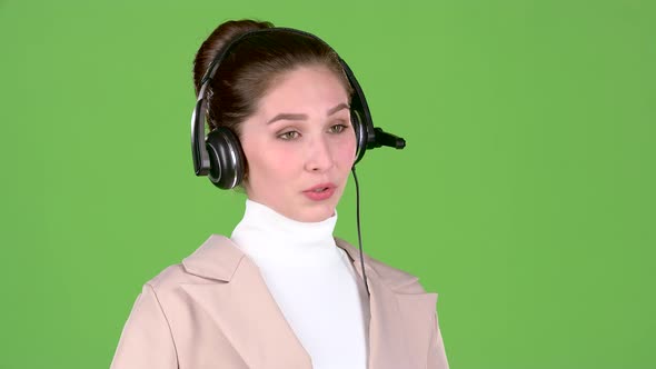 Manager in the Call Center Talks To the Customers on the Headset. Green Screen. Slow Motion