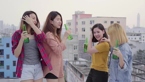 Group of young asian women people dancing and raising their arms up party on rooftop.