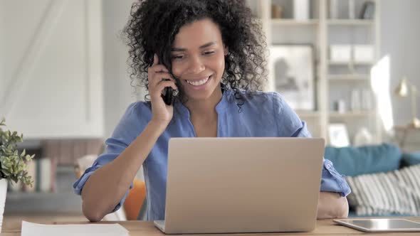 African Woman Talking on Phone at Work