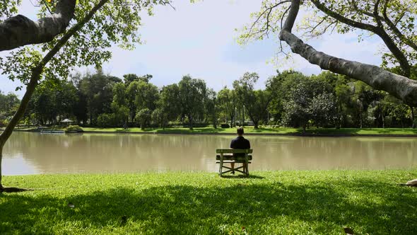 Alone Man Sit on Bench By Lake in Park Concept of Loneliness in Modern World