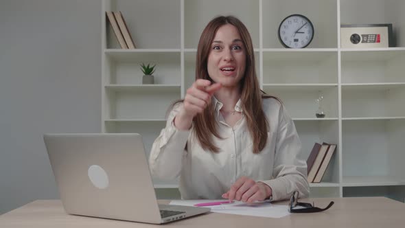 Smiling Beautiful Millennial Business Woman Sitting at Table Looking at Camera Holding Web Camera