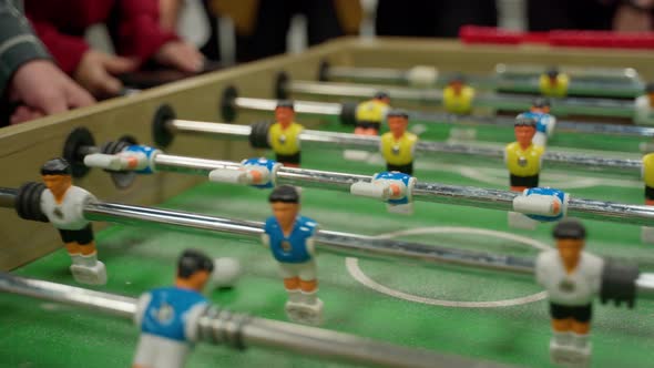 Unrecognizable people emotional play table football soccer closeup 4K. IT workers team resting