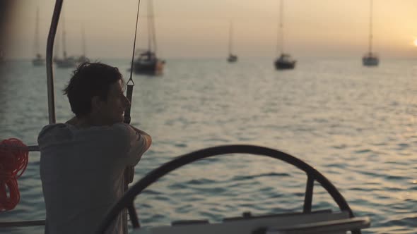 Man on a Yacht Enjoys Sunset on Cala Saona Bay