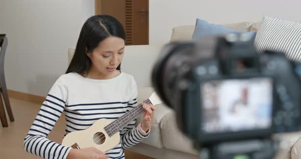 Woman teach the ukulele and take video on camera for social media