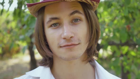 Close-up Portrait of a Young Man Looking at Camera in the Park or Garden