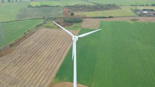 Pull back reveal of wind turbine in British countryside