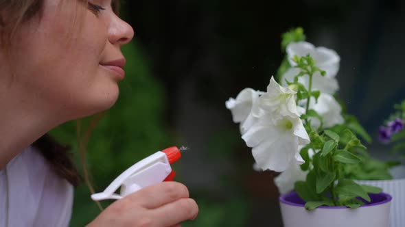 Closeup Side View Smiling Plussize Woman Spraying Water in White Flower Petals in Slow Motion