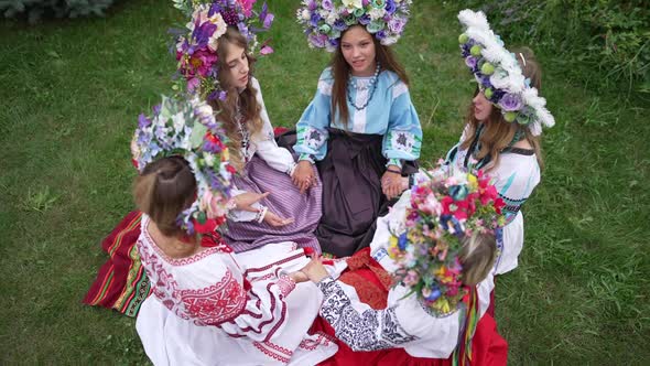High Angle View of Beautiful Ukrainian Women in National Clothes Holding Hands Sitting on Green