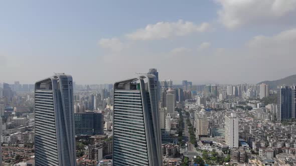 Panning aerial shot of Zhuhai cityscape and skyscrapers on clear sunny day