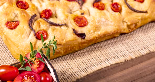 Traditional Italian Focaccia with cherry tomatoes, black olives and rosemary.